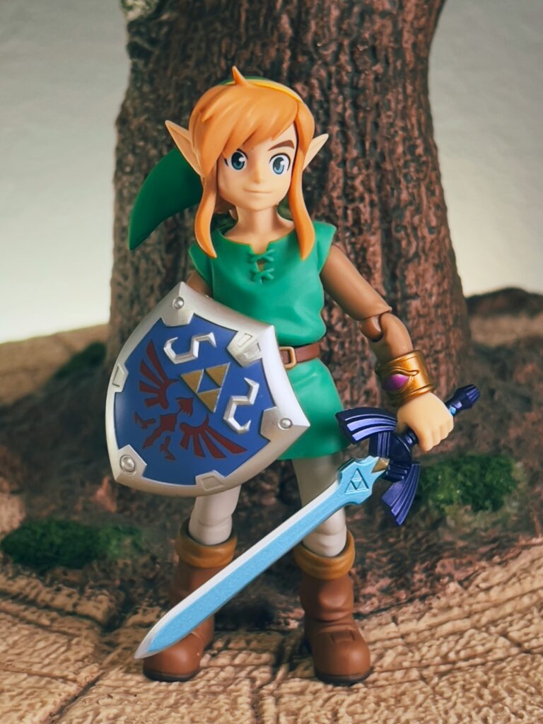 A toy version of Link from Zelda. Pictured with the triforce which could be a metaphor for the three jewels of buddhism